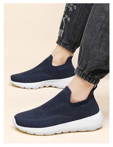 Detail of navy 3D knit sneakers on foot with breathable mesh and white cushioned sole