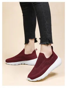 Detail of burgundy 3D knit slip-on sneakers with breathable texture and white sole