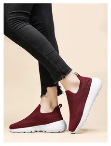 Detailed view of wine red 3D knitted slip-on sneakers with breathable mesh on model
