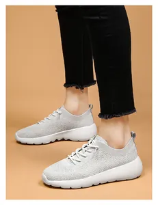 Gros plan de baskets de course légères en flyknit gris respirant avec semelle épaisse