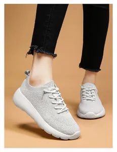 Gros plan de chaussures de course en tricot gris clair avec maille respirante