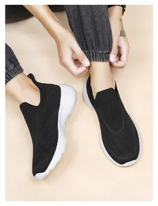 Detail view of black 3D flyknit slip-on sneakers with breathable mesh and white foam sole