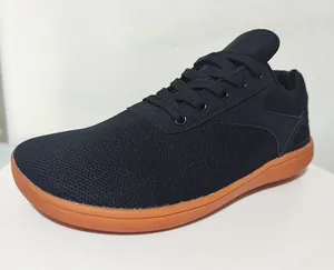 Close-up showing black breathable mesh fabric texture and vibrant orange rubber outsole