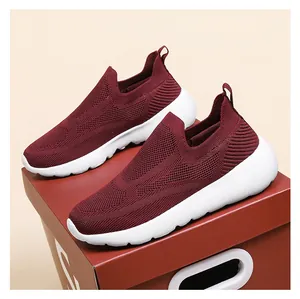 Detail of burgundy breathable 3D knit slip-on sneakers with white cushioned soles