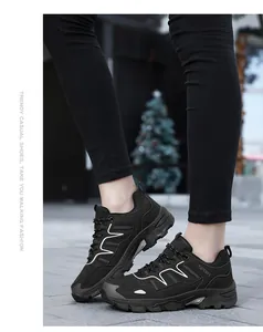 Dettaglio scarpe da trekking in mesh nero con motivi ondulati bianchi in ambiente esterno
