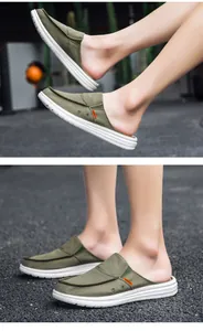 Detail of army green canvas mule loafers with fashion label on non-slip white soles