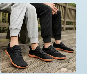Outdoor shot of minimalist wide-toe barefoot shoes with black mesh and orange rubber sole