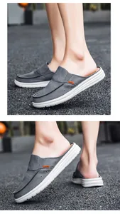 Detailed side view of grey canvas mule loafers with orange fashion label and rubber sole