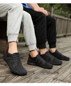 Gros plan de baskets en maille noire respirante sur une terrasse en bois naturel