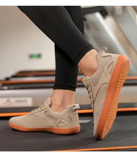 Detail of breathable beige mesh sneakers with vibrant orange anti-slip rubber soles