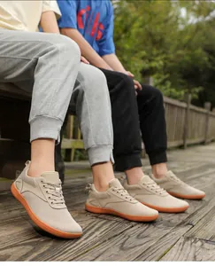 Macro shot of breathable mesh texture and orange anti-slip sole on beige walking sneakers