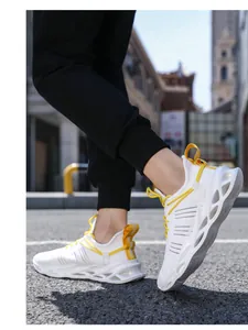 Macro shot of white breathable mesh sneakers featuring yellow laces and hollow blade soles