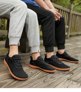 Outdoor lifestyle view of breathable black mesh sneakers with durable orange rubber soles