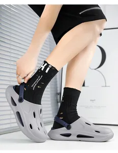 Side view of gray EVA clogs with drainage holes and blue adjustable heel strap worn with socks