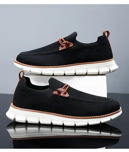 Detail of black breathable knit loafers with brown leather accents and thick white soles