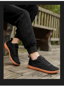 Outdoor view of lightweight barefoot running shoes with black knit upper and orange sole