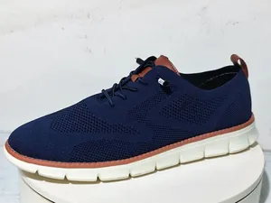 Close-up of navy breathable mesh fabric and brown leather accents on men's loafers