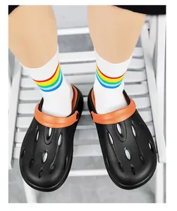 Top view of black breathable garden clogs with orange heel strap and stylish rainbow socks