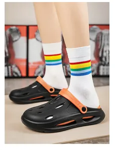 Detail of black and orange EVA clogs with side ventilation holes on a male model