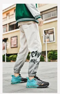 Macro detail of men's beige joggers featuring black RW letter printing and cuffed ankles
