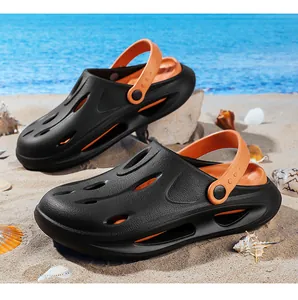 Detail of black and orange EVA clogs on a beach with thick platform and drainage holes