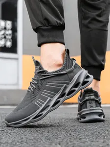 Detail of dark grey breathable mesh sneakers with wavy hollow blade soles on model