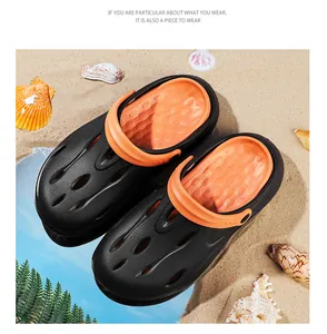 Detail of beach clogs featuring black EVA exterior and orange interior on sandy ground