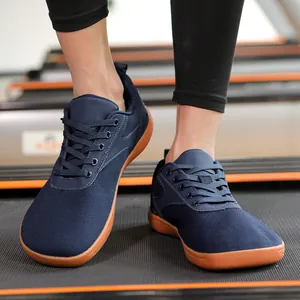 Detail of navy blue breathable mesh sneakers with durable brown rubber soles on treadmill