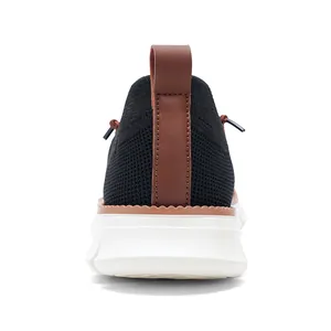 Rear view detail of black knit loafer with brown leather heel pull tab and white thick sole