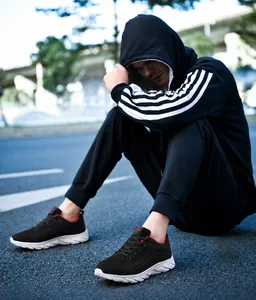 Outdoor low-angle view of lightweight black mesh running shoes with wavy white EVA outsoles