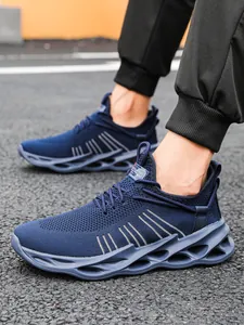 Detail of navy blue breathable mesh sneakers with hollowed cushioning sole on asphalt