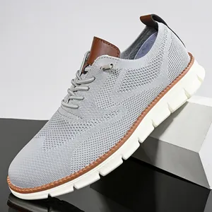 Detail of light gray breathable flyknit casual shoe with brown leather accents and thick sole