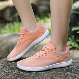 Detail of peach pink breathable mesh walking shoe with white flat sole and laces
