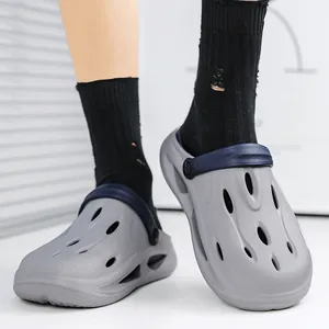 Men's light grey thick sole garden clogs with adjustable navy heel strap in casual setting