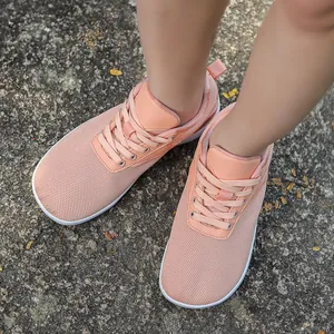 Close-up of pink breathable mesh barefoot sports shoes on a natural gravel path