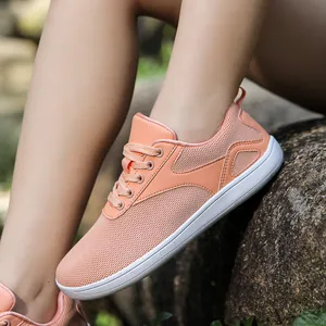 Detail of wide knit breathable sneakers in peach pink with thick white athletic soles