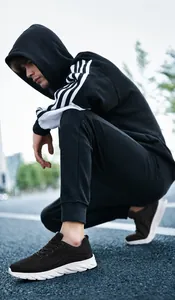 Outdoor street shot of breathable black mesh sneakers with soft white rubber soles on a model