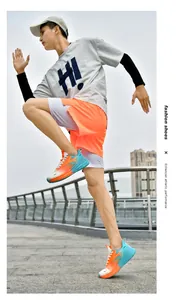 Dynamische Ansicht der orange-blauen Laufschuhe mit dicker Dämpfungssohle am Modell
