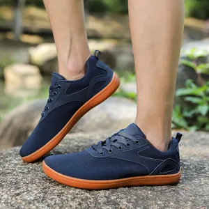 Macro detail of navy blue knit fabric and brown rubber sole on a barefoot sport shoe