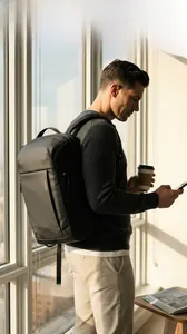 Waterproof black business backpack with MARK RYDEN logo in a modern office city setting