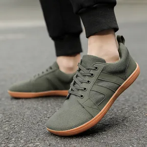 Men's army green breathable mesh sports shoes with brown flat rubber soles on the street
