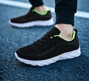 Detail of breathable black mesh running shoe with neon green lining and white thick sole