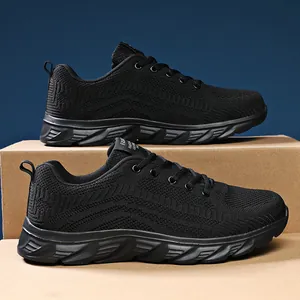 Detailed close-up of breathable knit mesh and slip-resistant rubber sole on black safety shoes