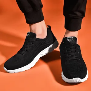 Close-up of black breathable knit running shoe with thick white non-slip sole on orange backdrop