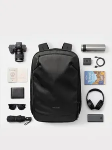 Large capacity black travel backpack flat lay showing interior storage with tech accessories