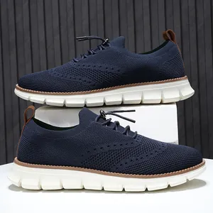 Detailed side view of breathable navy fly-knit men's loafers with a brown wave-pattern sole