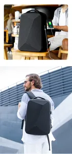 Detalle del puerto de carga USB externo y el diseño rígido geométrico en la mochila negra