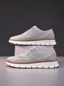 Detailed view of the breathable grey fly-knit fabric and brown leather accents on loafer