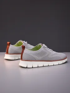 Close-up of breathable grey knit upper and brown leather heel detail on men's loafers