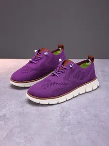 Detailed close-up of purple breathable knit loafer with brown leather accents and thick white sole